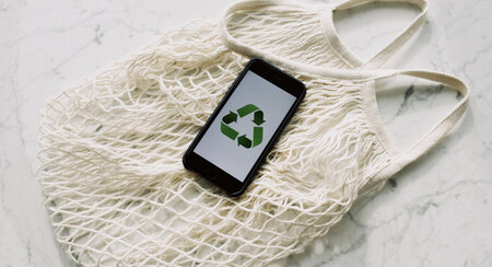 Mobile phone displaying a recycle logo on a mesh bag.