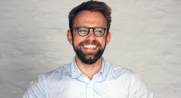 Man is smiling towards the camera