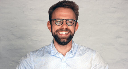 Man is smiling towards the camera